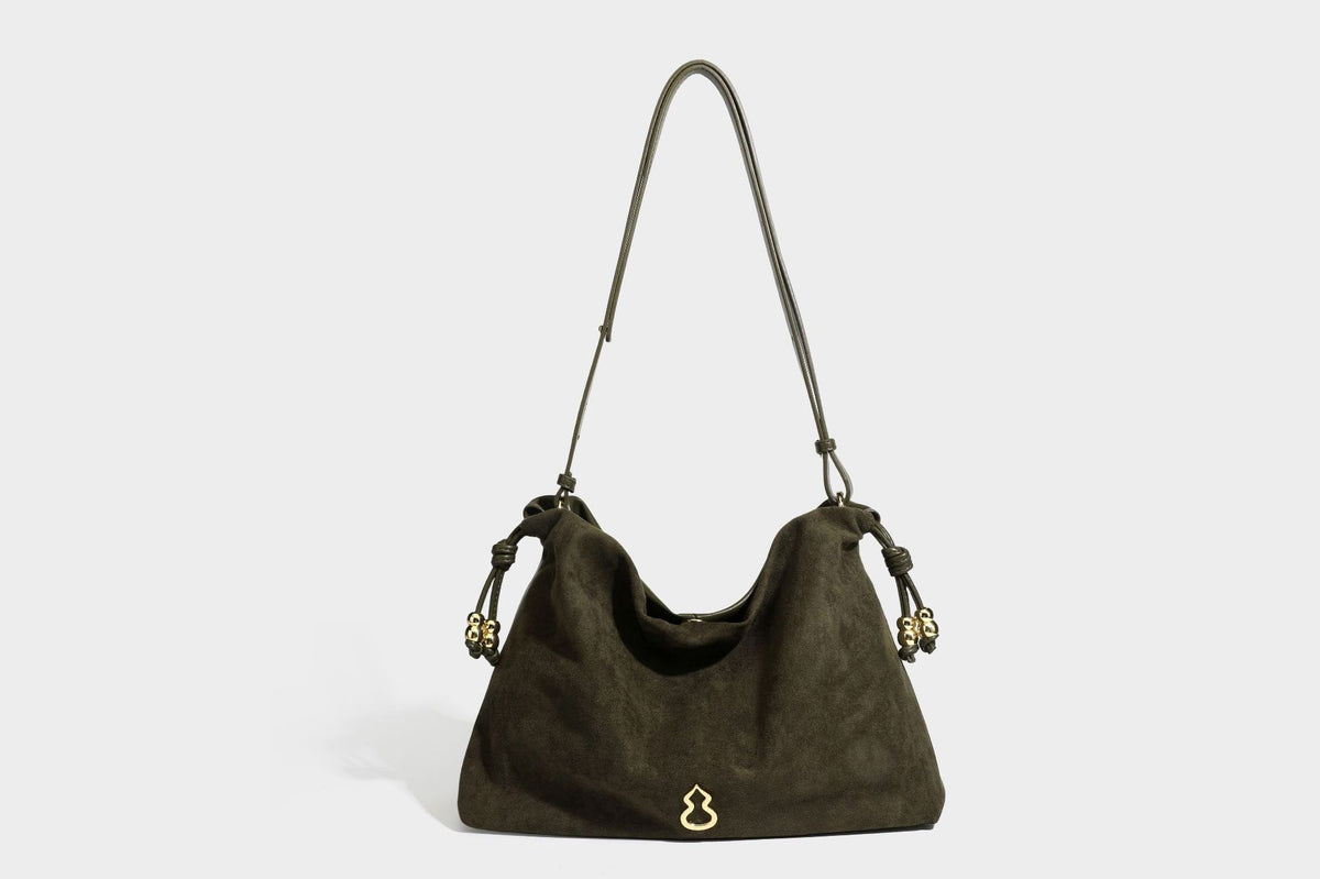 Suede-look drawstring shoulder bag in brown with smooth trim, knotted bead drawstring closure, slim adjustable strap, and
