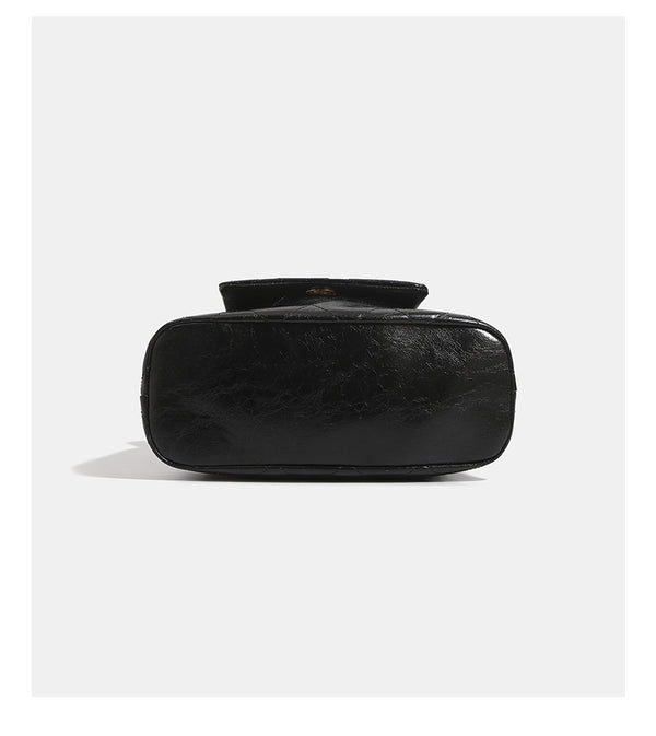 Black glossy diamond-quilted bucket tote bag with gold-tone chain accent, turn-lock front flap pocket, drawstring side ties