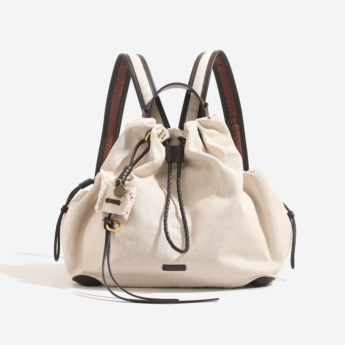 Weicher Rucksack in Beutelform mit Kordelzug und geflochtenem Kordelverschluss, Besätzen in hellbrauner Lederoptik und Eckenschutz, Detailansicht 6