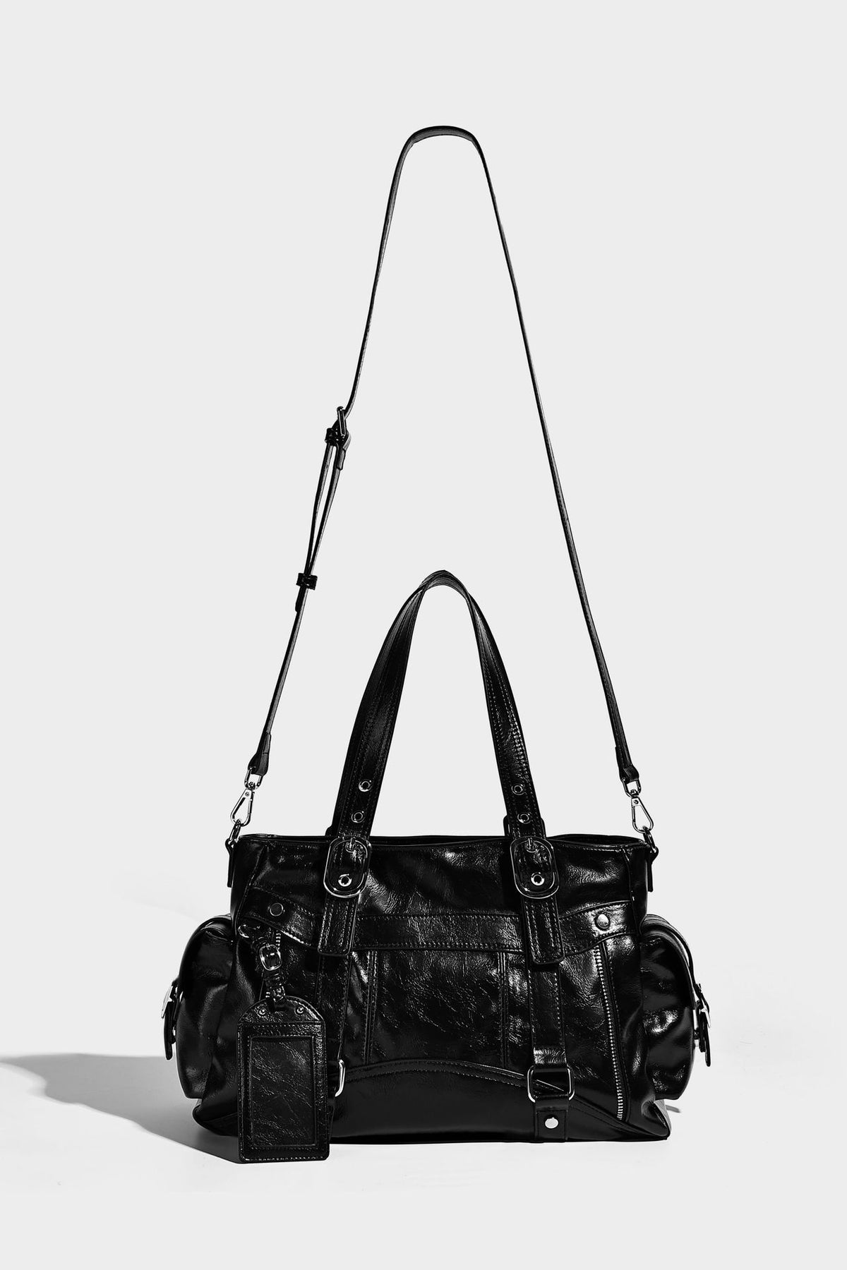 Glossy structured black tote shoulder bag with silver buckle hardware, zip pockets, dual top handles, and detachable, detail