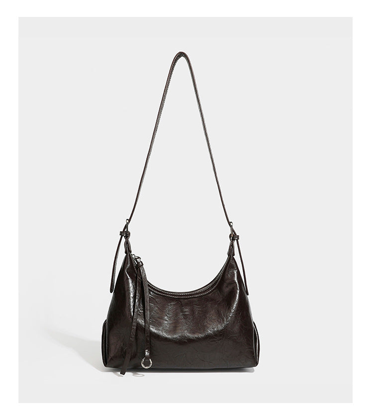Slouchy hobo shoulder bag in glossy crinkled leather-look finish with zip-top closure and silver-tone ring hardware, detail