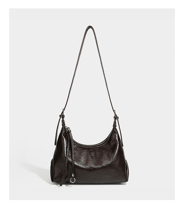 Slouchy hobo shoulder bag in glossy crinkled leather-look finish with zip-top closure and silver-tone ring hardware, detail