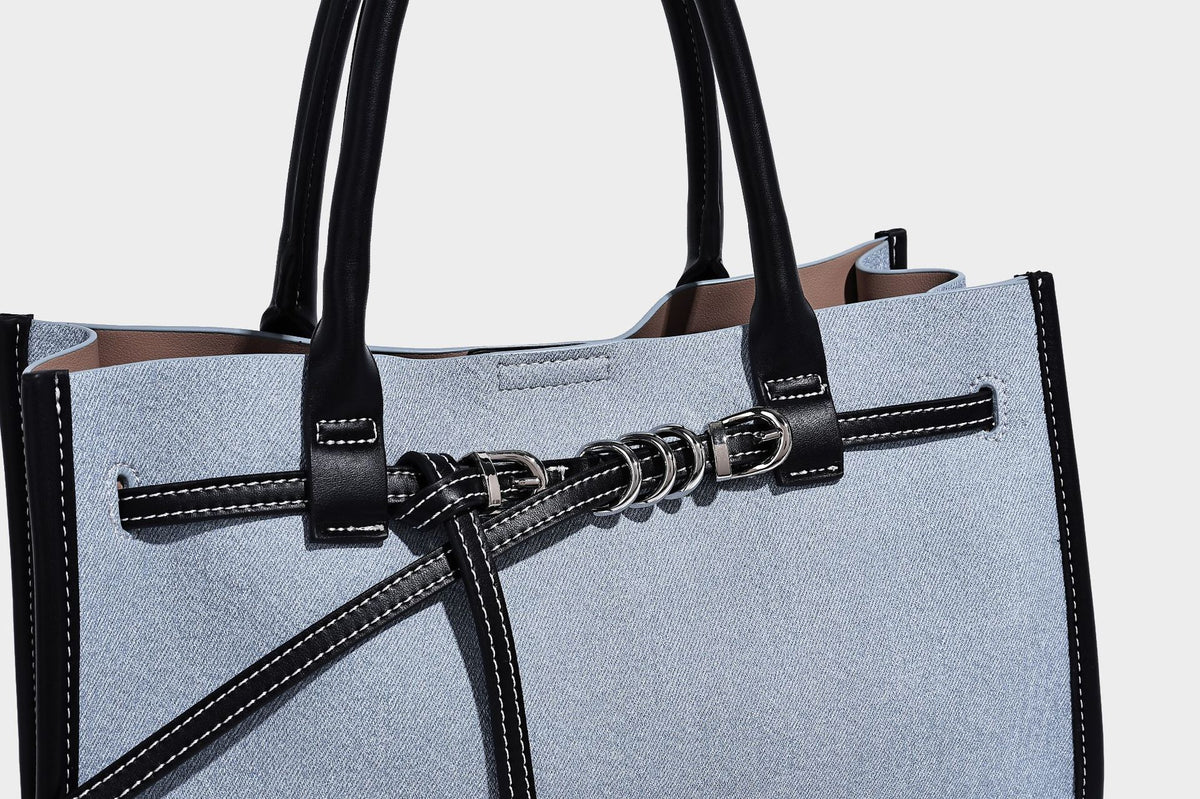 Structured rectangular tote satchel in denim-look fabric with dark trim, knotted front strap hardware, and detachable, detail