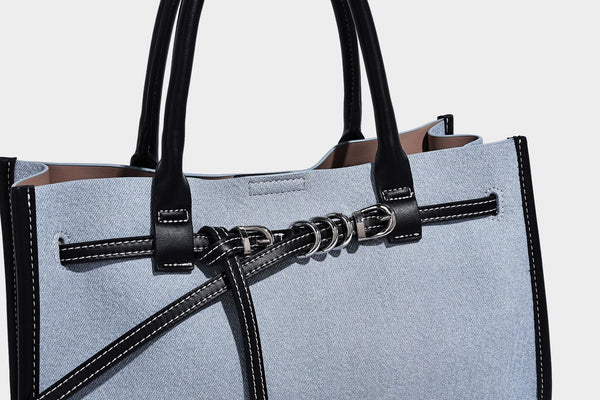 Structured rectangular tote satchel in denim-look fabric with dark trim, knotted front strap hardware, and detachable, detail