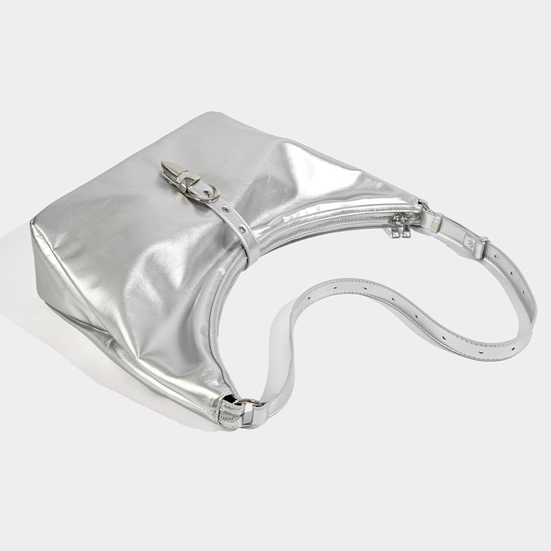 Slouchy crescent hobo bag with glossy leather-look finish, silver-tone buckle hardware, and flat shoulder strap, detail view