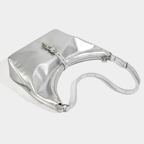 Slouchy crescent hobo bag with glossy leather-look finish, silver-tone buckle hardware, and flat shoulder strap, detail view