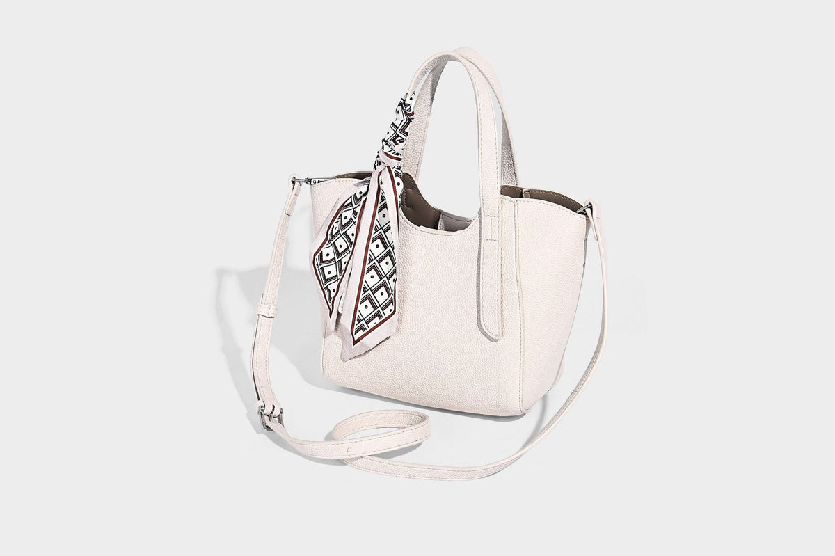 Structured pebbled leather-look tote bag with detachable scarf tie, dual top handles, and adjustable crossbody strap, detail