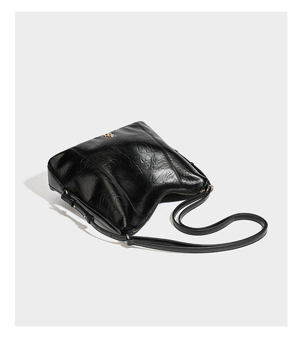 Große, lässig fallende Hobo-Schultertasche in glänzender, geknautschter Lederoptik mit goldfarbenen Beschlägen und langem, verstellbarem Riemen