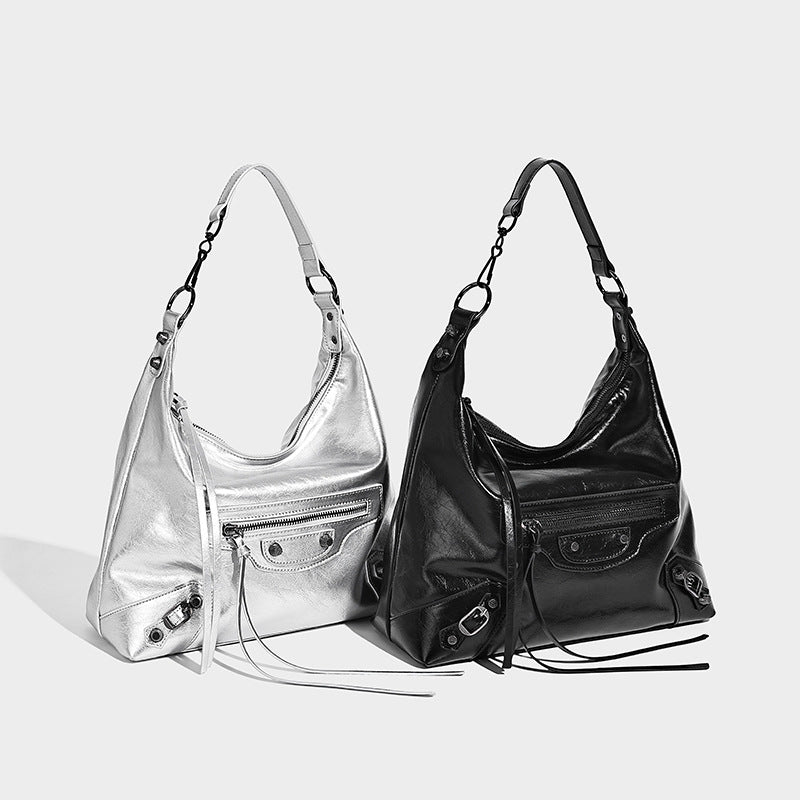 Large glossy crinkled hobo shoulder bag with dark metal studs, zip closure, front zip pocket, and adjustable crossbody strap