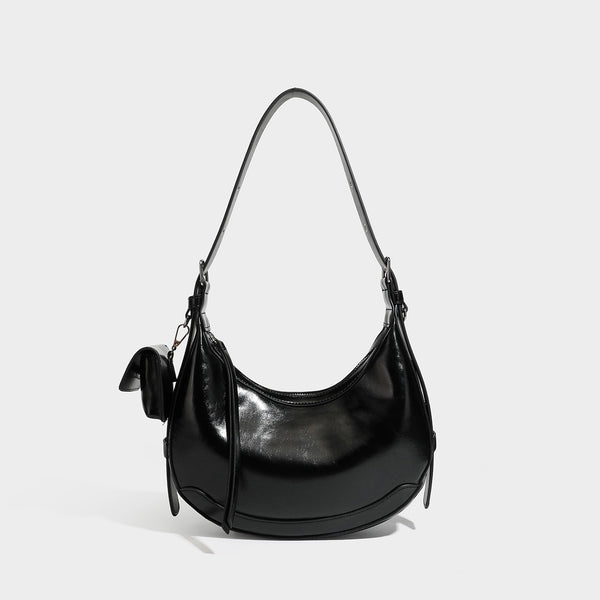 Glossy leather-look crescent hobo shoulder bag with dark contrast trim, silver-tone hardware, and attached mini flap pouch