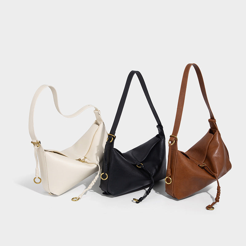 Slouchy brown leather-look shoulder bag with knotted drawcord tie closure, gold-tone ring hardware, and long adjustable