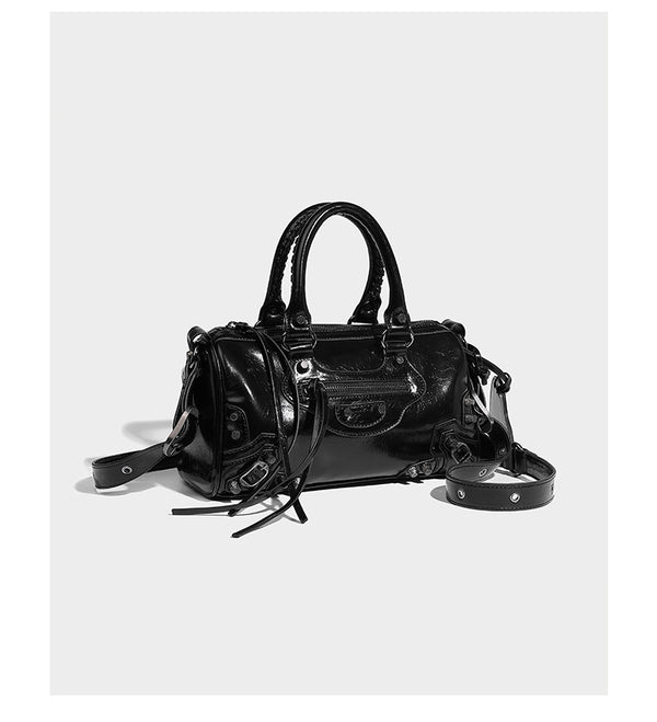 Glossy studded mini satchel bag with braided top handles, front zip pocket, heart charm, and detachable crossbody strap