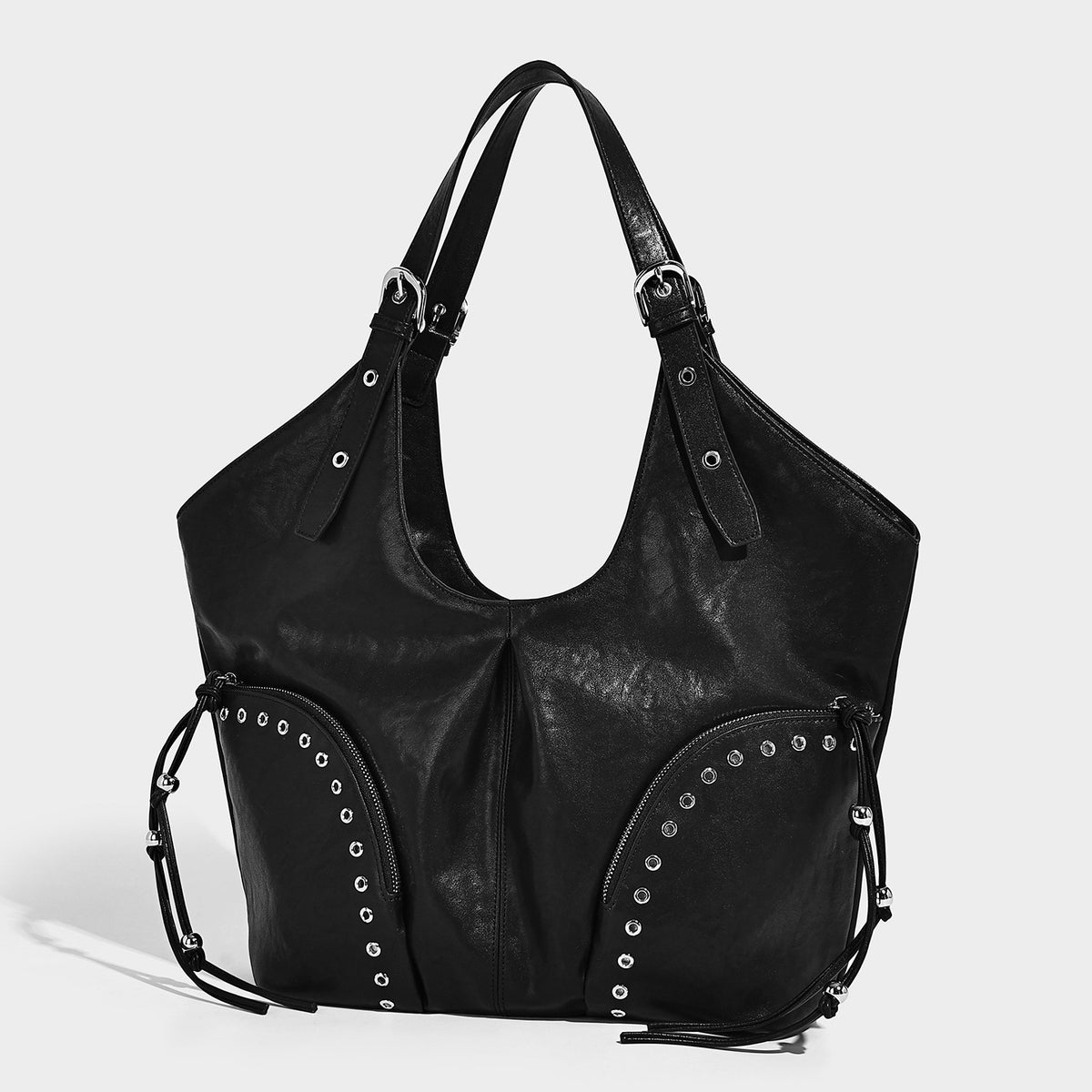 Large slouchy leather-look hobo shoulder bag with silver rivets, grommet-trimmed front zip pockets, and adjustable dual