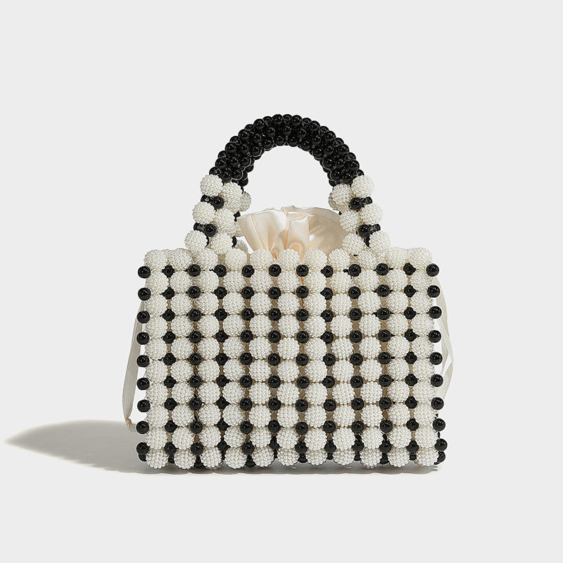 Small boxy pearl-bead mini top-handle bag with silver metallic bead accents, satin floral detail, and long beaded shoulder
