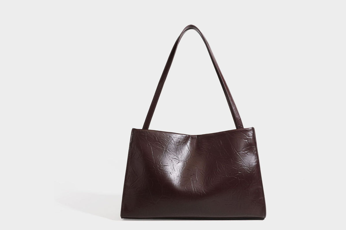 Strukturierte rechteckige Tote-Schultertasche aus glänzender, geknitterter Lederoptik mit langen Doppelträgern und Emblem in Goldoptik