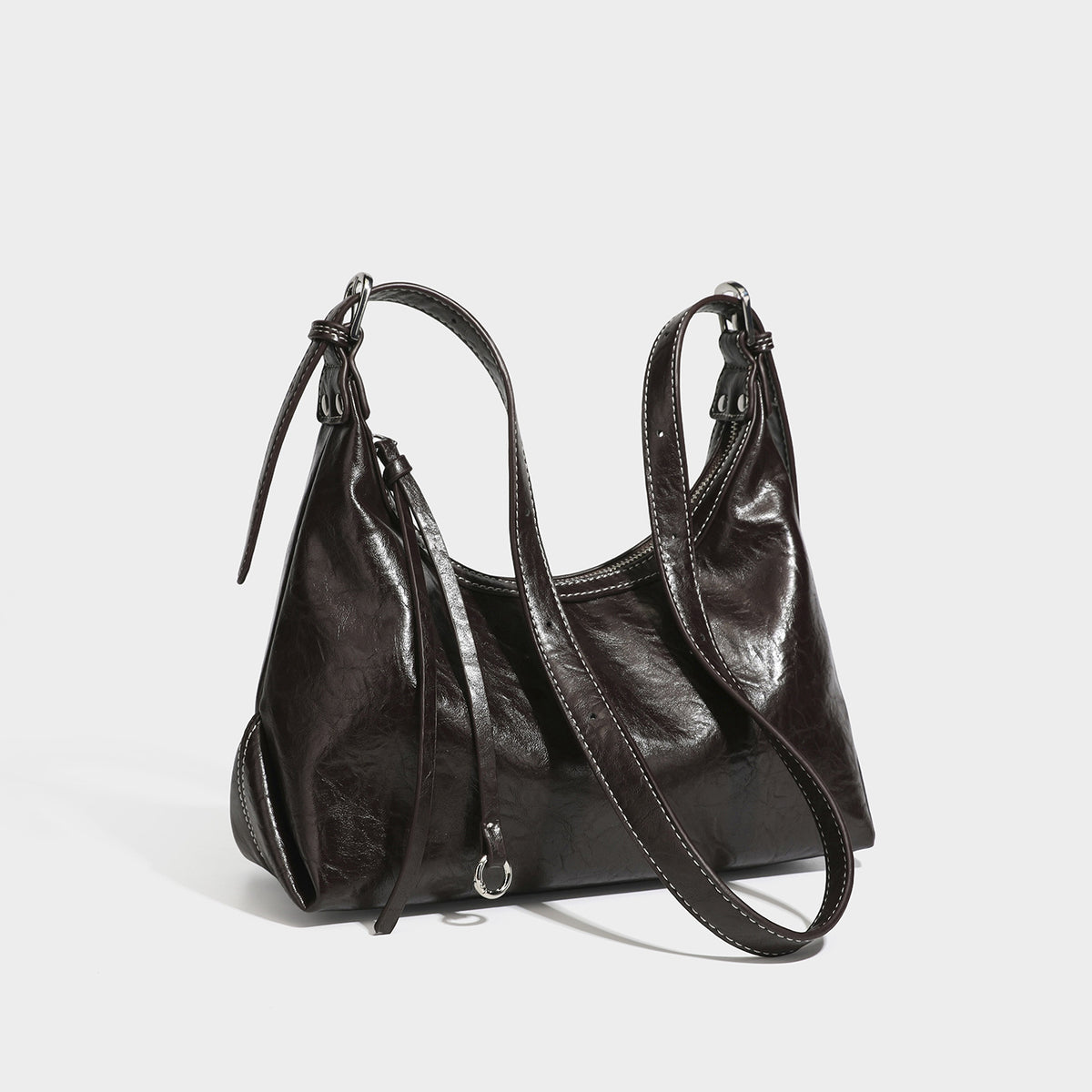 Slouchy hobo shoulder bag in glossy crinkled leather-look finish with zip-top closure and silver-tone ring hardware, detail