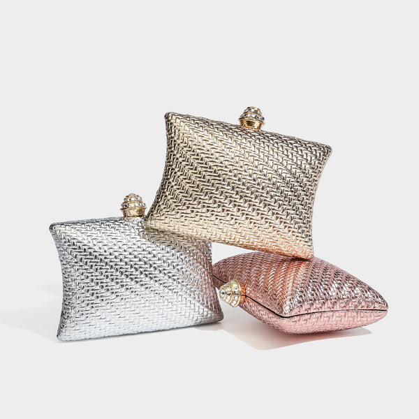 Small structured rectangular metallic woven-texture clutch bag with jeweled knob clasp and gold-tone chain strap, detail view