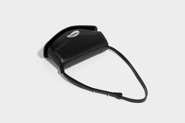 Small structured saddle bag with glossy leather-look finish, angular flap front, silver-tone metal clasp, and slim