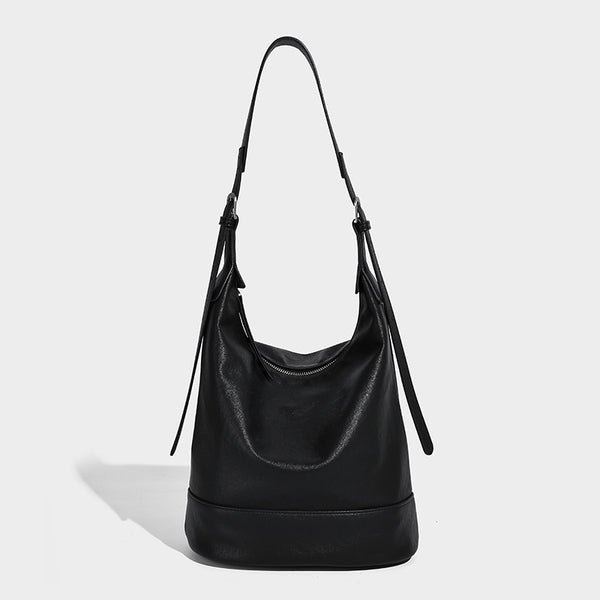 Slouchy bucket hobo shoulder bag in dark brown with glossy leather-look finish, top zip closure, and long adjustable, detail
