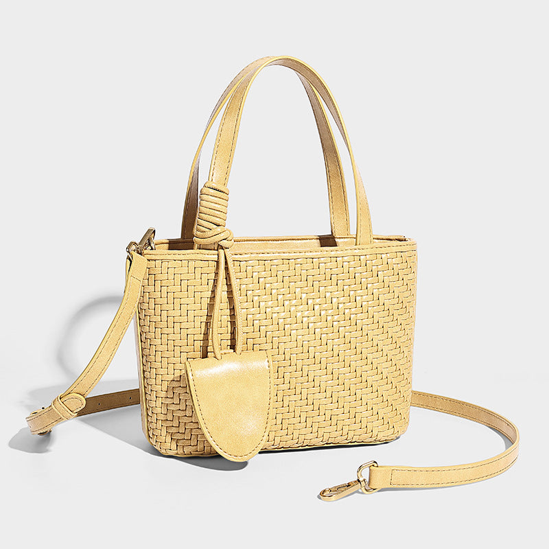 Small structured woven leather-look tote bag with knotted top handles, detachable shoulder strap, and hanging mini front