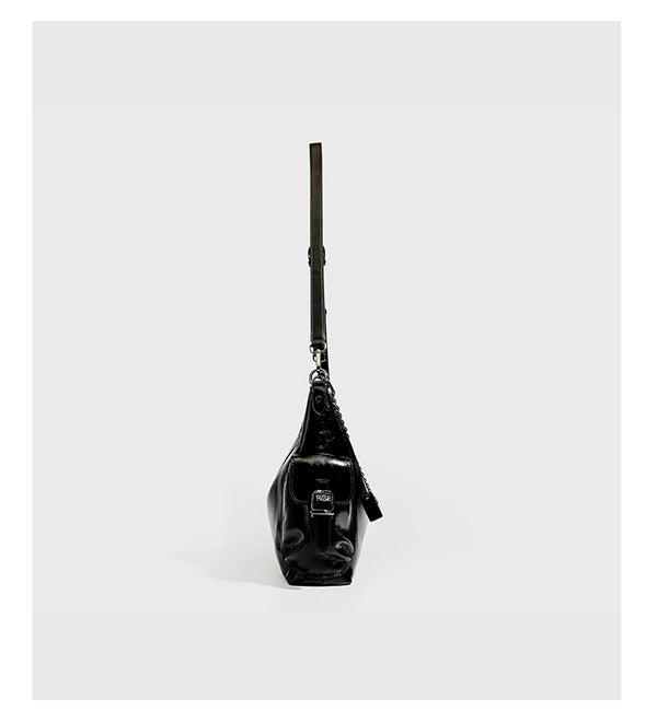 Slouchy hobo shoulder bag with glossy leather-look finish, silver-tone chain drape across front, side buckle pockets, and