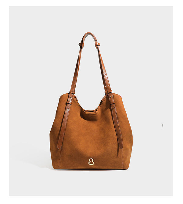 Oversized suede-finish tote shoulder bag in caramel brown with slim leather-look straps and gold-tone logo hardware, detail