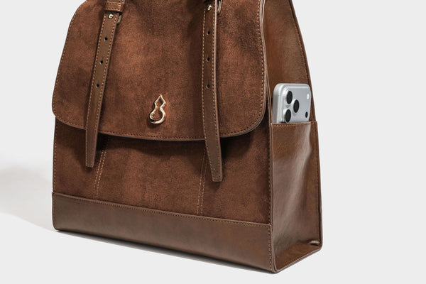 Structured suede-look convertible backpack handbag with flap closure and gold-tone emblem hardware in chocolate brown, detail