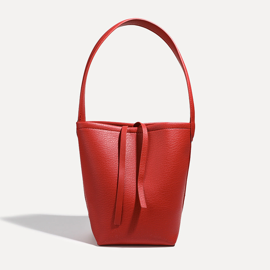 Mini tapered bucket bag in pebbled leather-look finish with front tie straps and single shoulder strap, detail view 8