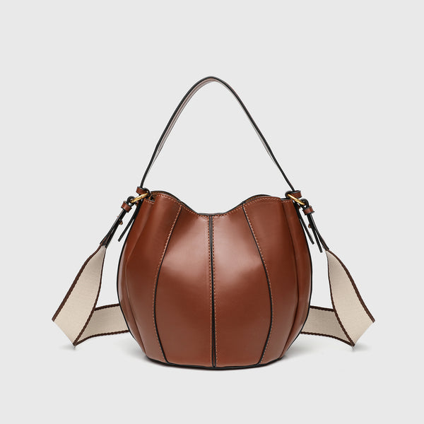 Smooth leather-look paneled bucket bag in brown with wide woven shoulder strap, gold-tone ring hardware, and detachable zip