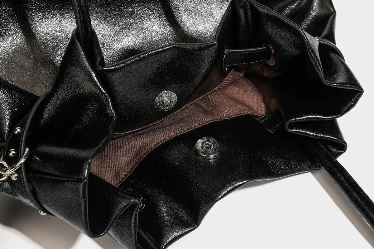 Glänzende schwarze, weich fallende Schultertasche mit gerafftem Abschluss, zwei langen Trageriemen, silberfarbenen Beschlägen und abnehmbarem Umhängeriemen