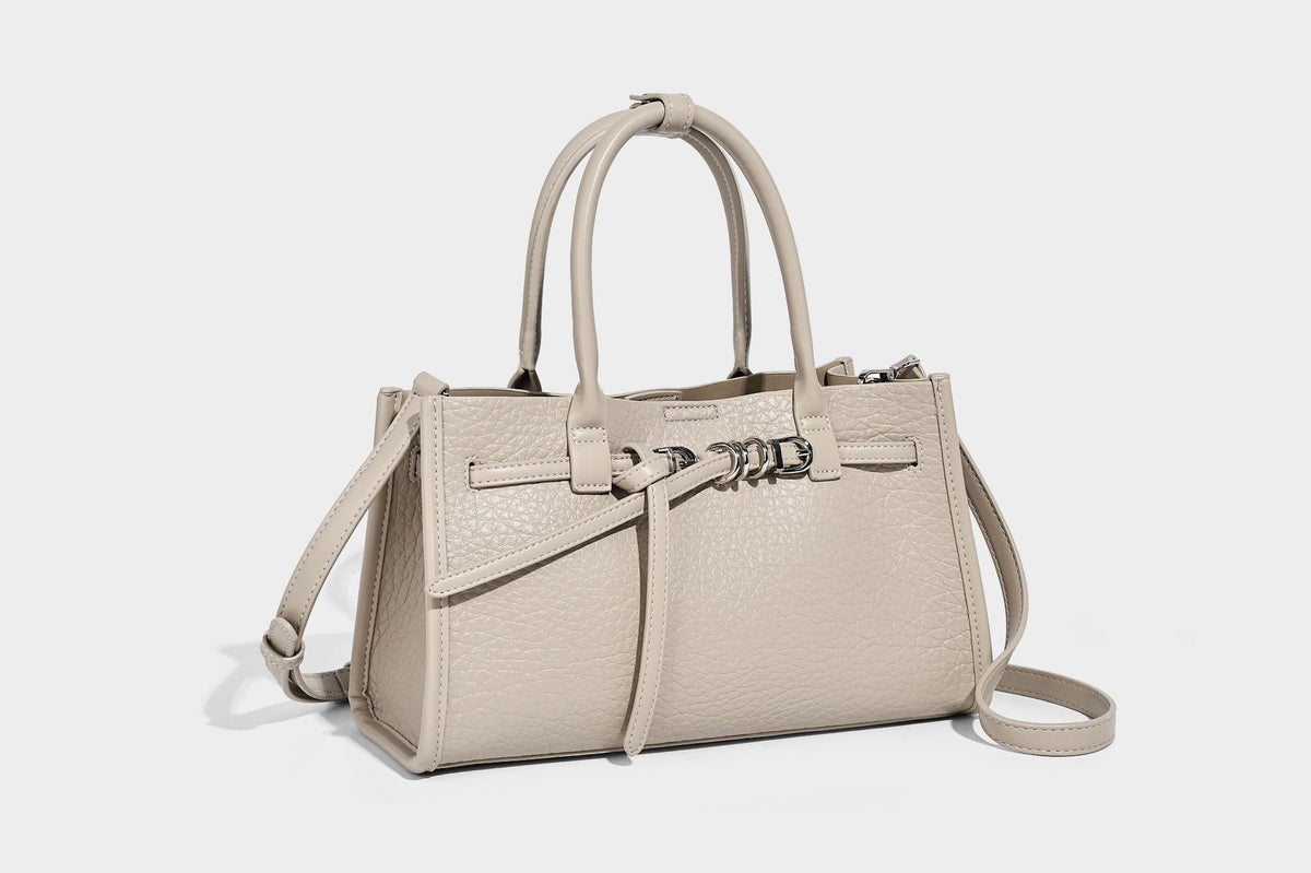 Structured trapezoid tote bag in pebbled leather-look finish with double top handles, silver-tone bar hardware, and, detail