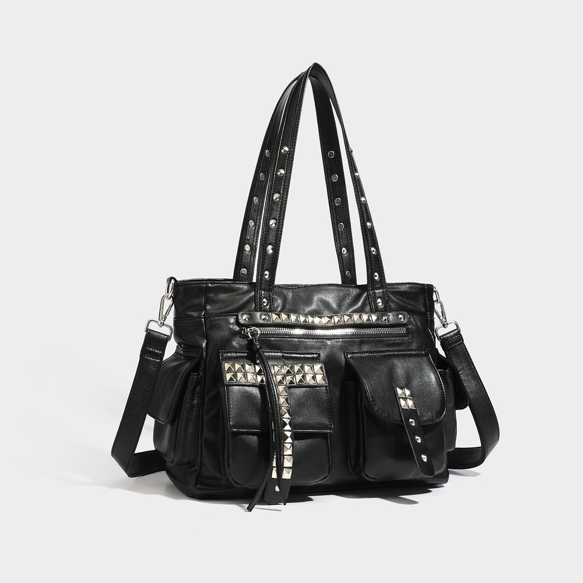 Black leather-look tote bag with silver pyramid studs on handles and front panel, multiple flap and zip exterior pockets