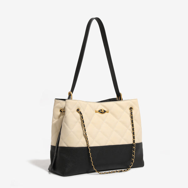 Large quilted two-tone shoulder tote bag with gold-tone chain handles and eye-shaped clasp hardware, detail view 3