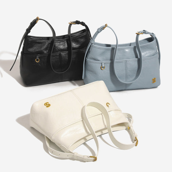 Relaxed leather-look shoulder tote bag in cream white with front exterior pocket, gold-tone ring hardware, and adjustable