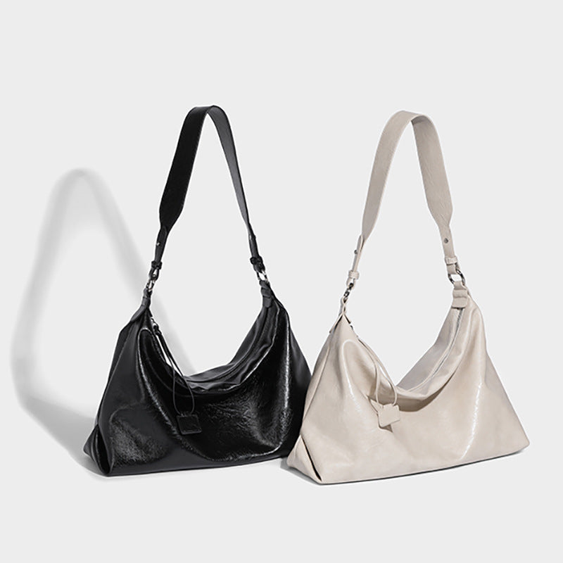 Weich fallende Hobo-Schultertasche mit glänzender, geknautschter Oberfläche, Reißverschluss an der Oberseite und verstellbarem Trageriemen, Detailansicht 2