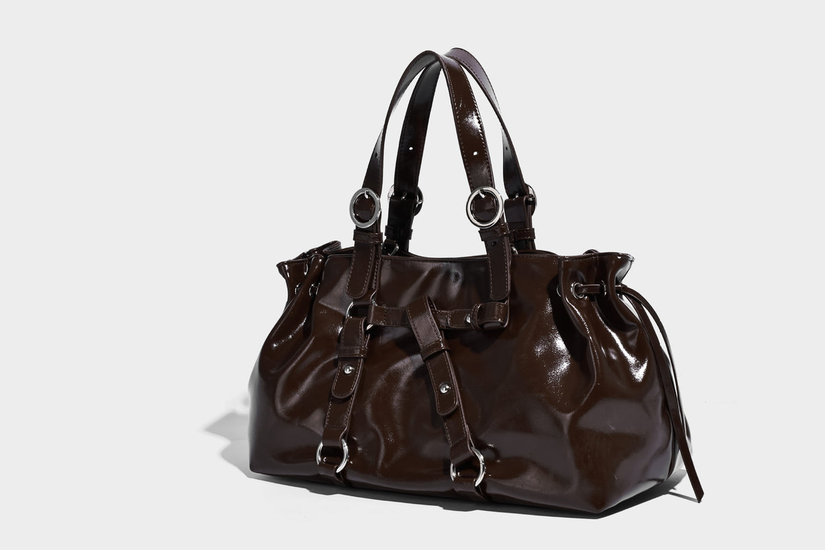 Glossy patent-look slouchy tote bag with ruched drawstring sides, dual top handles, silver ring hardware, and detachable