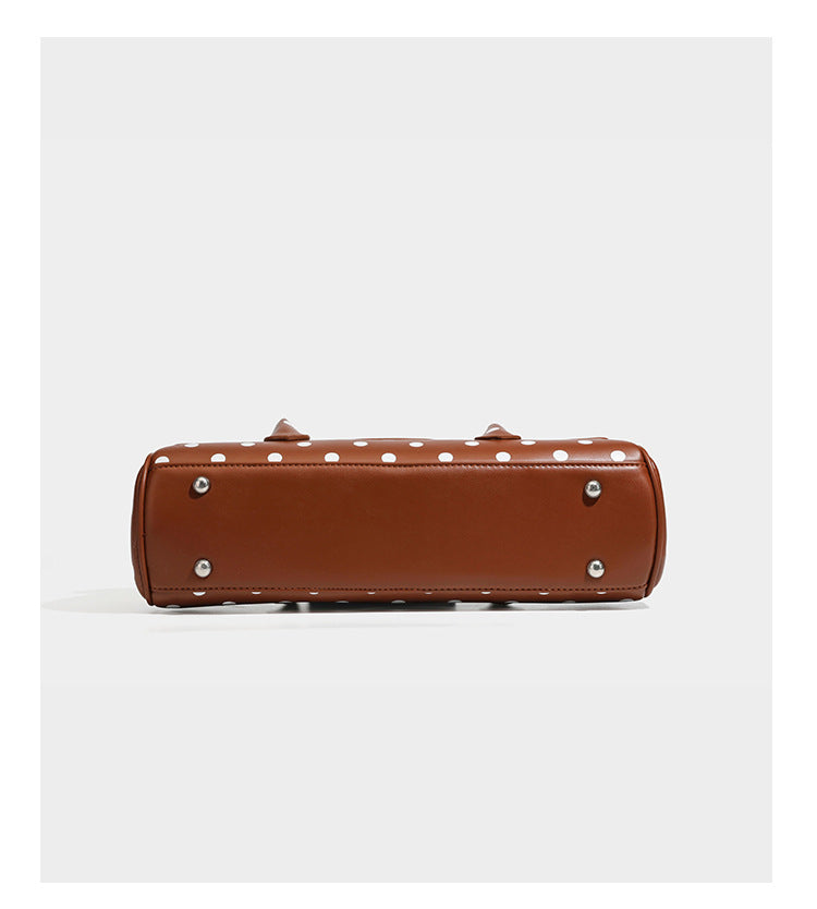 Strukturierte Baguette-Tasche mit Polka-Dot-Muster, glänzender Lederoptik, zwei Tragegriffen, silberfarbener Drehverschlussklappe und