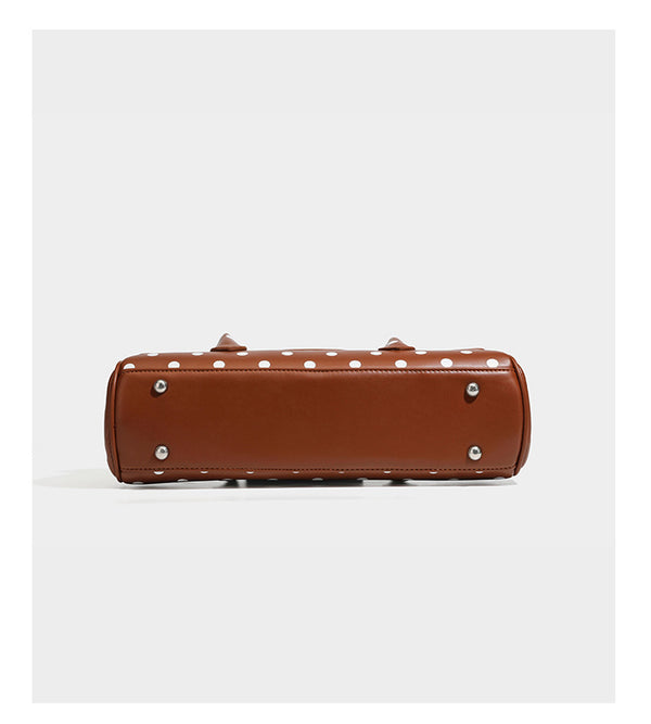 Strukturierte Baguette-Tasche mit Polka-Dot-Muster, glänzender Lederoptik, zwei Tragegriffen, silberfarbener Drehverschlussklappe und