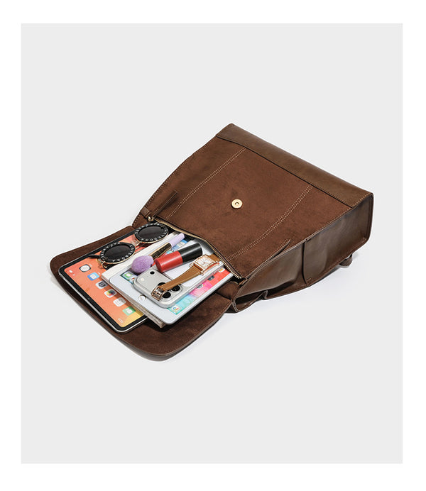 Structured suede-look convertible backpack handbag with flap closure and gold-tone emblem hardware in chocolate brown, detail