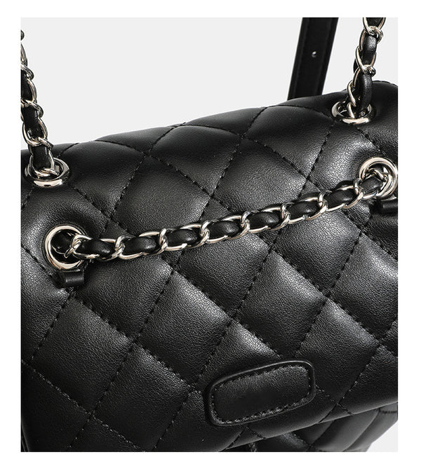 Black diamond-quilted backpack handbag with silver-tone chain flap accent and adjustable shoulder straps, detail view 21