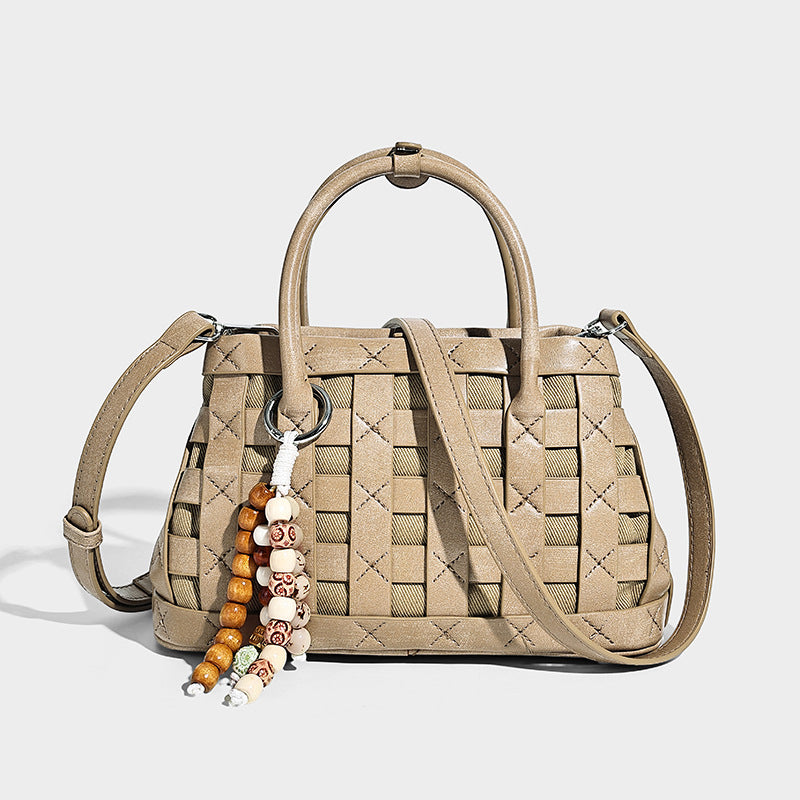 Small structured woven satchel tote with rounded top handles, silver-tone ring hardware, and bead tassel charm, detail view 7