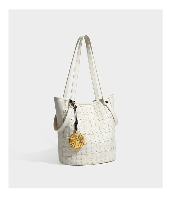 Brown embossed geometric woven leather-look bucket tote bag with dual shoulder straps, side snap hardware, and a round
