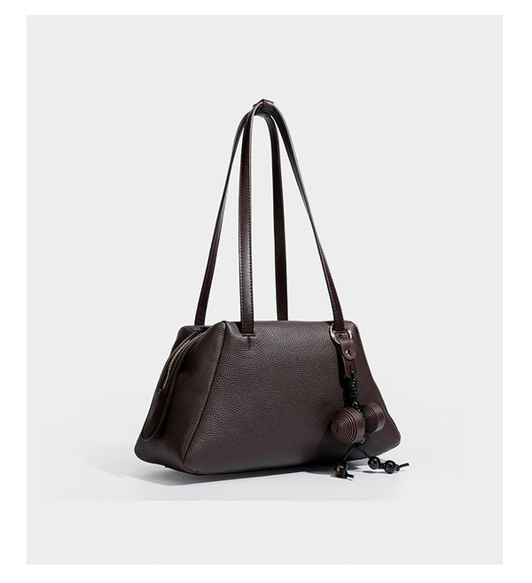 Structured trapezoid shoulder bag in dark brown pebbled leather-look finish with slim double straps, top zip closure, side