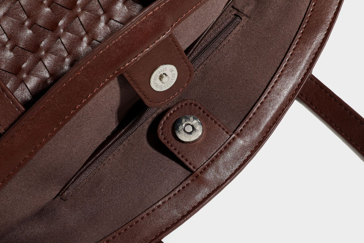 Large leather-look tote bag with geometric woven emboss, double shoulder straps, and round woven cord charm in brown, detail
