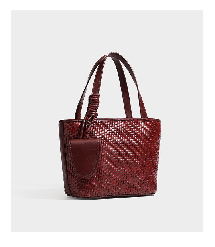 Strukturierte Tote Bag mit gewebter Oberfläche in Braun, goldfarbenen Metalldetails, seilumwickelten Tragegriffen, einer kleinen Fronttasche und weiteren Details