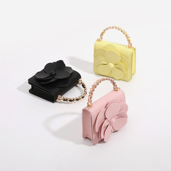 Small structured rectangular crossbody bag with layered 3D flower appliqué and gold-tone chain strap, detail view 2