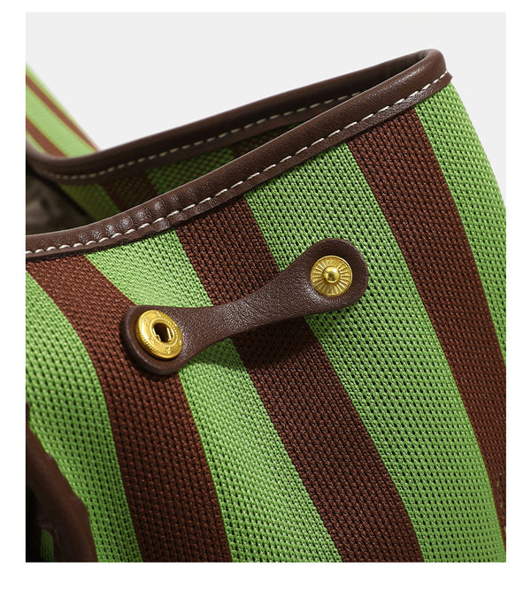 Structured striped canvas convertible satchel bag with leather-look trim, gold-tone buckle hardware, and backpack straps