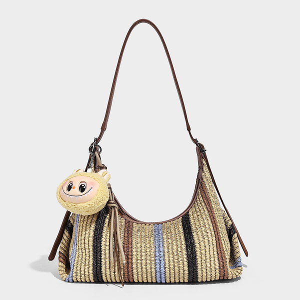 Slouchy woven straw hobo shoulder bag with beige, black, brown, and blue vertical stripes and brown leather-look trim, detail