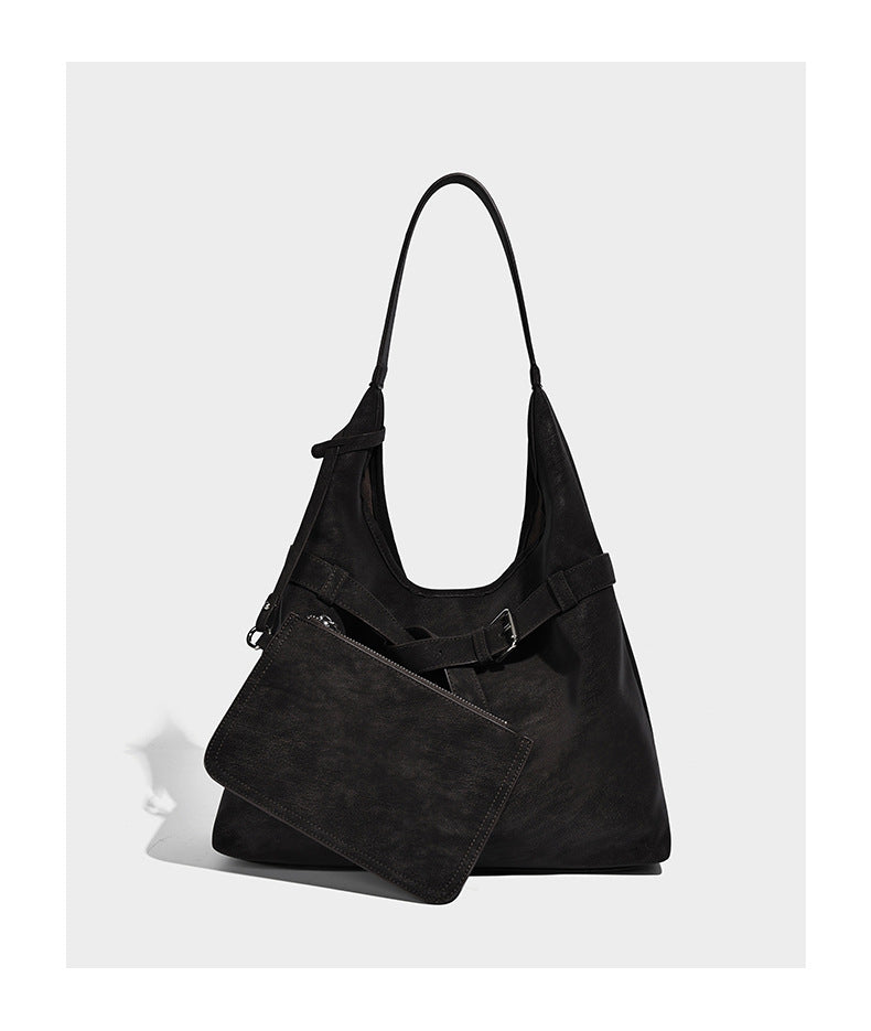 Slouchy oversized shoulder tote bag with matte textured finish, wrap-around buckle strap, and detachable front zip pouch