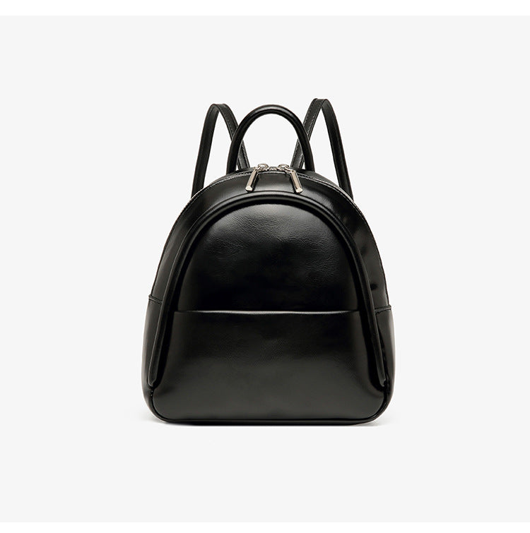 Kleine kuppelförmige Mini-Rucksackhandtasche in Pastellgelb mit glatter Lederoptik, oberem Bogenreißverschluss und silberfarbenen Details, Detailansicht